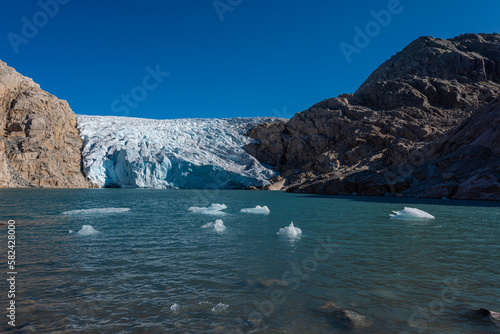 Iceberg floats in crystal clear water of Mosevatnet Lake with Folgefonna Glacier in the background © Krzysztof Wiktor