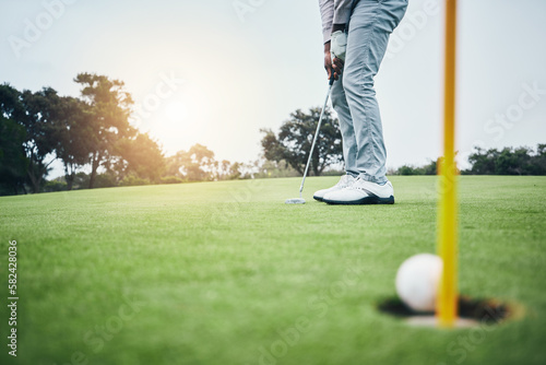 Ground, golf hole and man with golfing club on course for game, practice and training for competition. Professional golfer, sports and male athlete hit ball on grass for winning, score or tee stroke photo