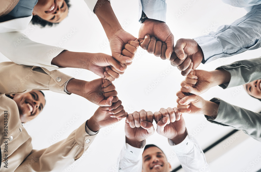 Obraz premium Team building, circle or happy business people fist bump for motivation in office meeting together. Diversity, low angle or employees with mission, strategy or group support for project goal