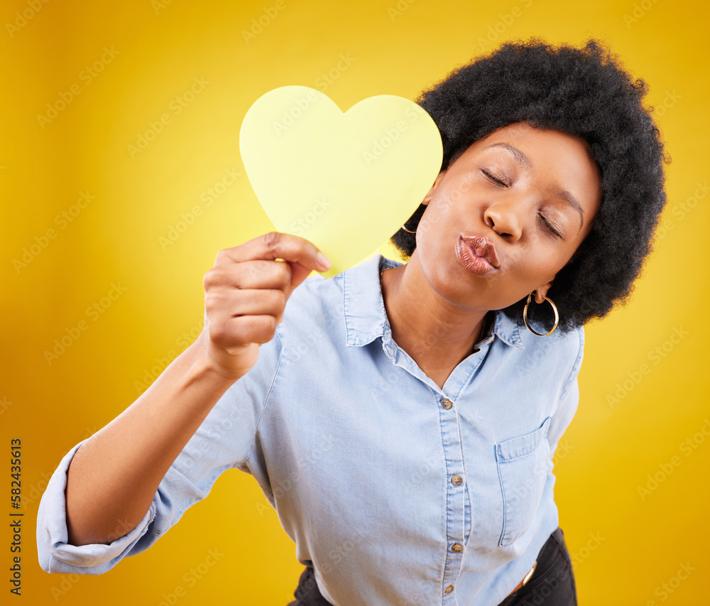 Paper, heart and kiss with black woman in studio for romance, positive and emotion. Happiness, love shape and giving with female isolated on yellow background for date, feelings and affectionate Paper, heart and kiss with black woman in studio for romance, positive and emotion. Happiness, love shape and giving with female isolated on yellow background for date, feelings and affectionate