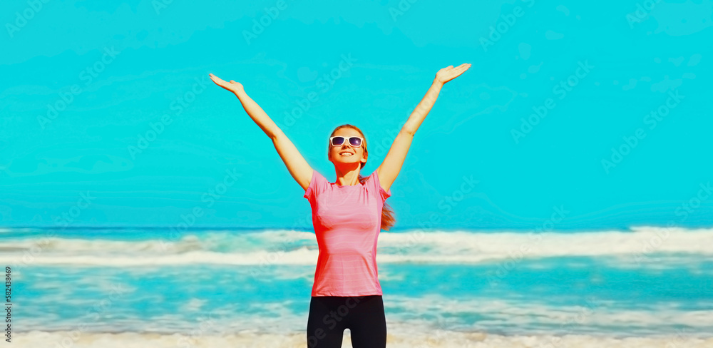 Happy smiling young woman rising her hands up on the beach on sea Happy smiling young woman rising her hands up on the beach on sea