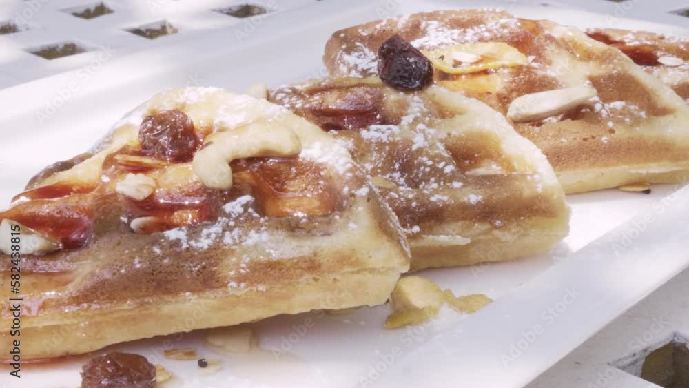 Waffles on a plate topped with honey and strawberry jam. Waffles on a plate topped with honey and strawberry jam.