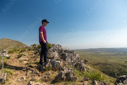 young man looking and contemplating a beautiful nature and landscape of countryside and mountains