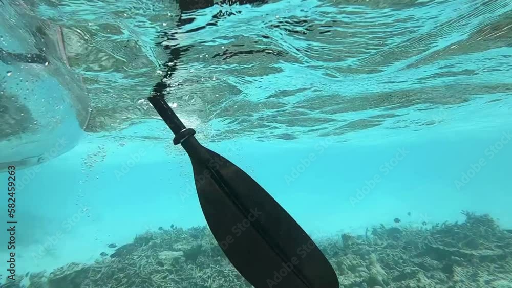 Unterwasseraufnahme von einem Paddeln von einem Kanu im Korallenriff in Zeitlupe