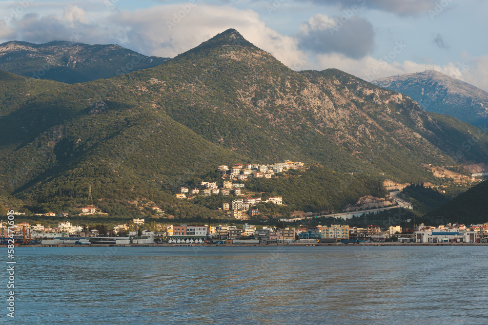 View of Igoumenitsa city harbor, with passenger port, ferry terminal, mountains and Ionian sea, Epirus, Thesprotia, Greece in a summer sunny day with blue sky