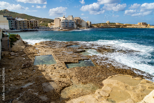 The salt pans in Qbajjar Bay  Gozo  with the Qolla l-Bajda Battery in the background.