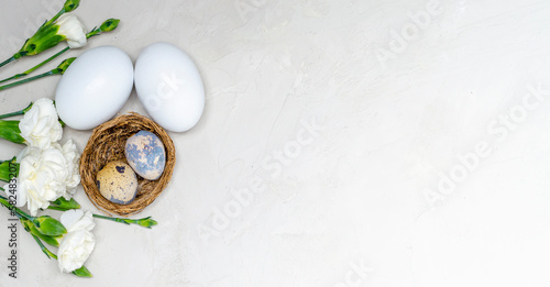 Festive Easter background. Easter colorful eggs with flowers on a white table. Flat styling
