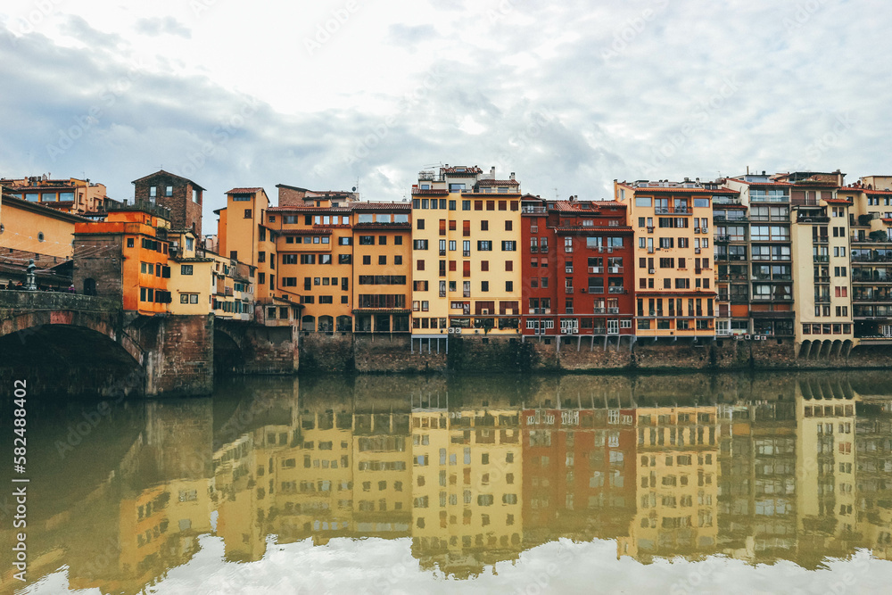Colorful buildings by the river in italian town and bridge
