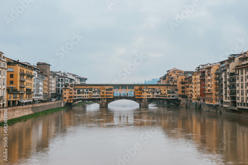 Colorful symmetrical old famous bridge by the river in italian town