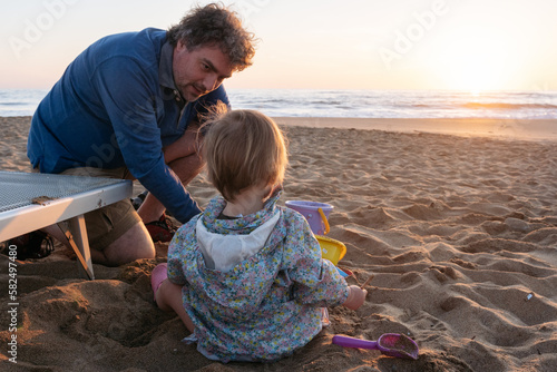 Wallpaper Mural Father and child sitting at the beach in the sunset Torontodigital.ca