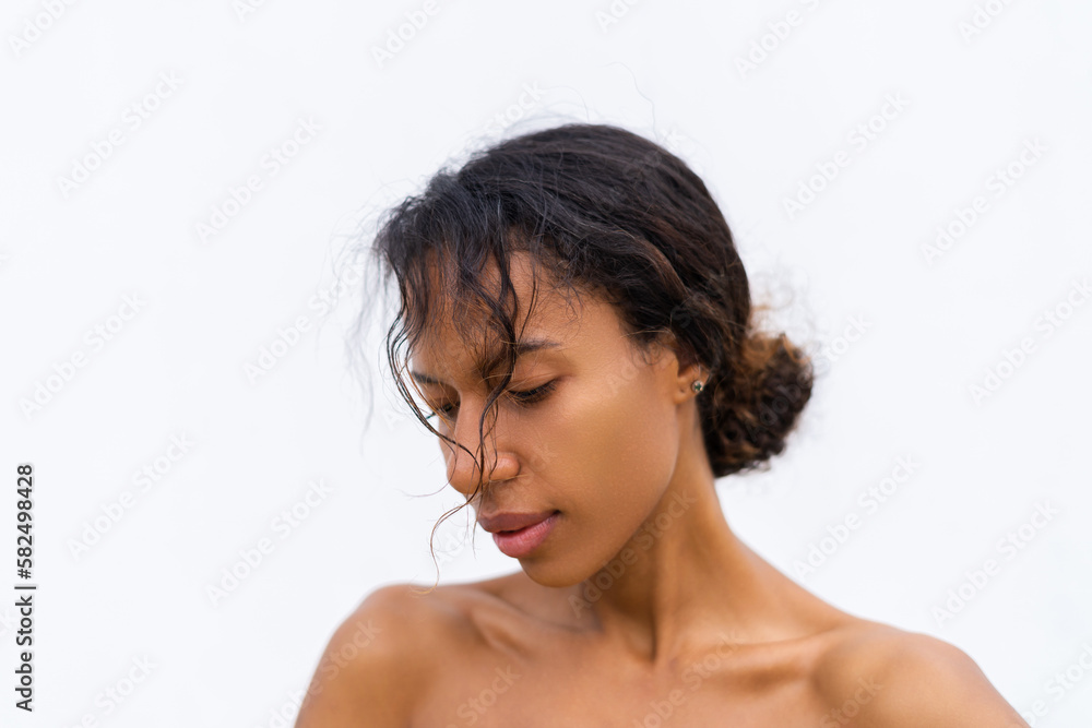 Beauty portrait of young topless african american woman with bare shoulders on white background with perfect skin and natural makeup positive Beauty portrait of young topless african american woman with bare shoulders on white background with perfect skin and natural makeup positive