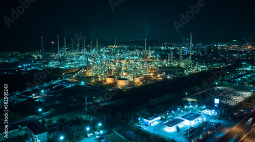 cityscape night scene shot oil storage tank and oil refinery factory zone, global business and industry about natural resources wasteful for transportation and trading, aerial view