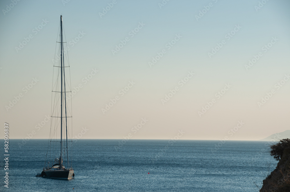 A sailboat off the coast of the Greek Island Ios at sunset
