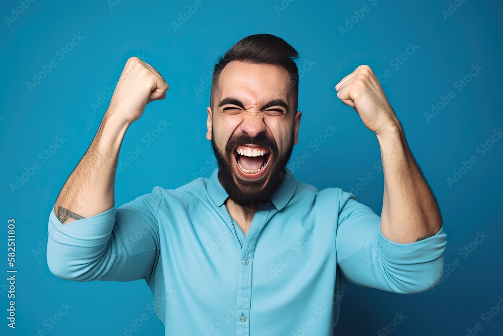 Fototapeta premium Portrait of a Man with Fists in the Air Celebrating Success,/Win on a Blue Background (Generative Ai)