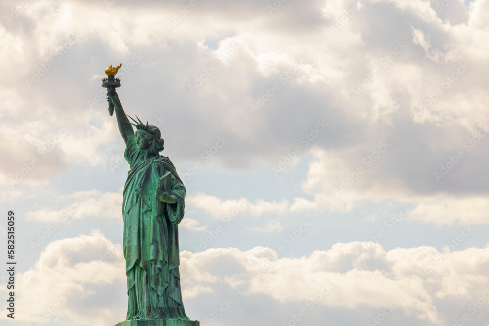 Fototapeta premium Beautiful view of famous Statue of liberty isolated on sky with white clouds background. New York, USA. 