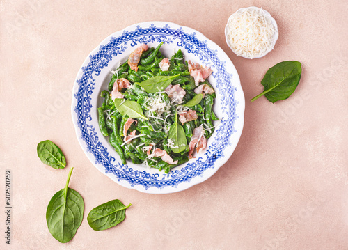  Gnocchi alla tirolese or Spaetzle (spätzle), fresh pasta an irregular shape. Recipe of spinach gnocchi with pancetta and creamy sauce sprinkled with grated Parmesan. Tirol, Trentino-Alto Adige, Italy photo