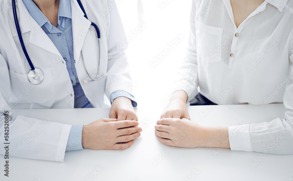 Doctor and patient discussing current health questions while sitting near of each other at the table in clinic, just hands closeup. Medicine concept Doctor and patient discussing current health questions while sitting near of each other at the table in clinic, just hands closeup. Medicine concept