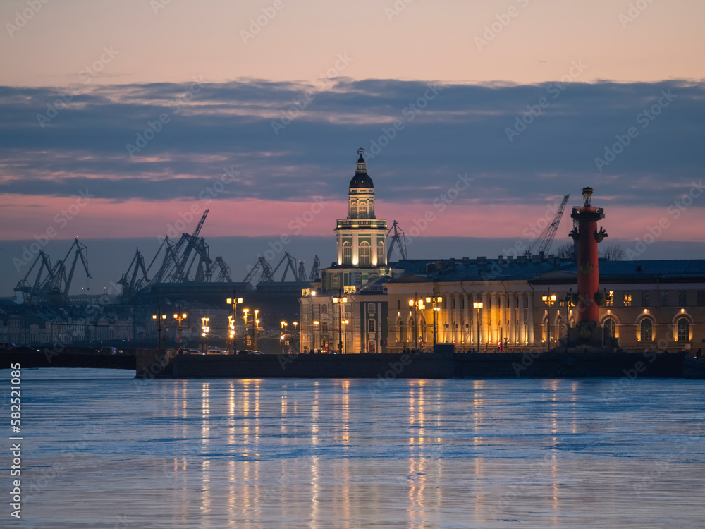Duwn city center. Spring evening in St. Petersburg. Ice on the Neva River. View of the Rastral columns and Cabinet of curiosities at sunset, city life, postcard view of the evening city.
