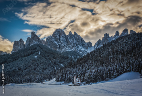 St. Magdalena or Santa Maddalena with its characteristic church in front of the Geisler or Odle dolomites mountain peaks in the Val di Funes Villnosstal in Italy in winter. January 2023. Long exposure photo