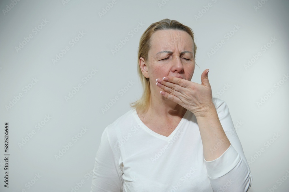woman is tired she is bored yawns covering mouth white background housewife real person no hairstyle no makeup woman is tired she is bored yawns covering mouth white background housewife real person no hairstyle no makeup