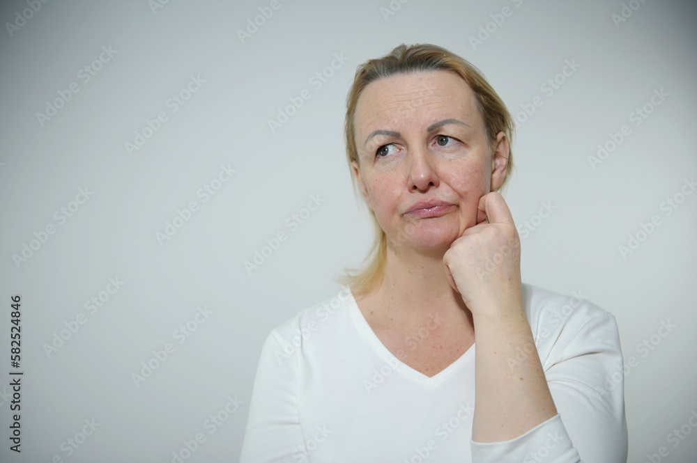 adult fair-haired woman is upset and dissatisfied she looked away put hand to cheek and pursed lips sad eyes adult fair-haired woman is upset and dissatisfied she looked away put hand to cheek and pursed lips sad eyes