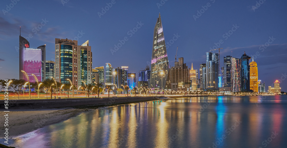 Doha Qatar skyline from corniche promenade at dusk showing West Bay