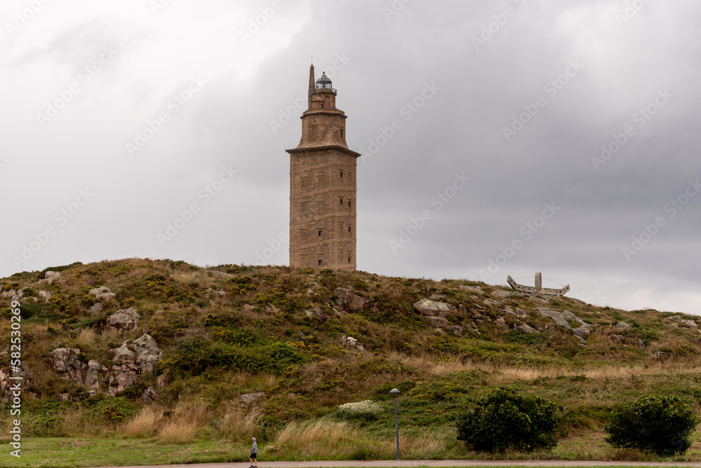The Torre de Hercules, an ancient Roman lighthouse and a symbol of La Coruña, Galicia, Spain, stands tall against the blue sky, offering a glimpse into the region's rich history and culture