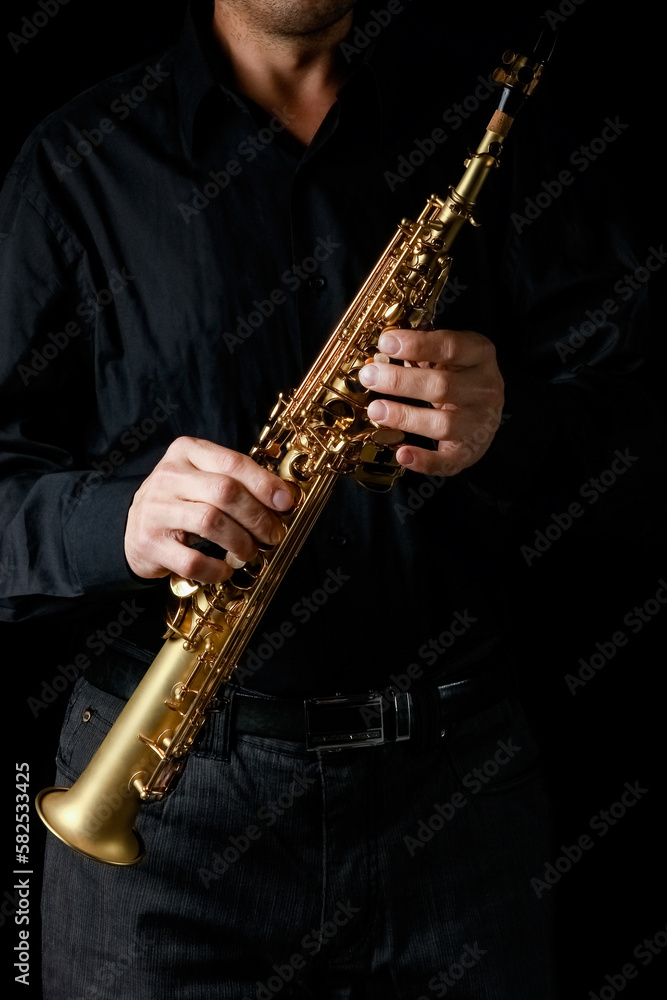 Obraz premium soprano saxophone in hands on a black background