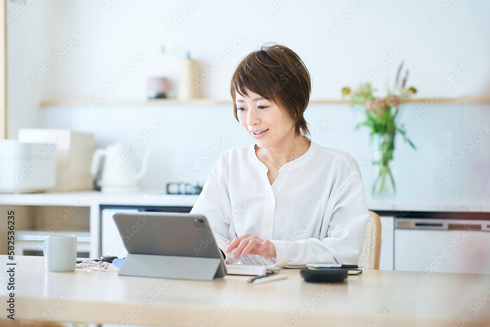 自宅のダイニングキッチンで仕事をする女性 自宅のダイニングキッチンで仕事をする女性