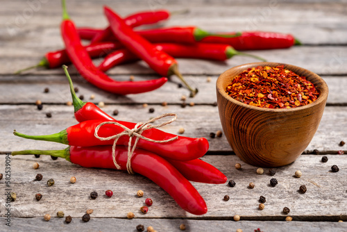 Crushed red chili pepper on wooden background © deil82