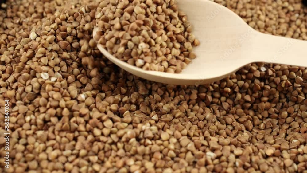 buckwheat groats close-up in a wooden spoon pouring background food video for cooking buckwheat groats close-up in a wooden spoon pouring background food video for cooking