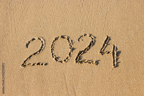 2024 number on a sand beach. Abstract background photo of coming New Year 2024