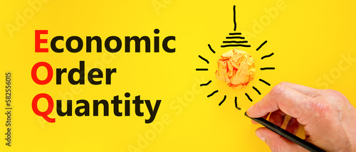 EOQ economic order quantity symbol. Concept words EOQ economic order quantity on paper on beautiful yellow background. Orange light bulb icon. Business EOQ economic order quantity concept. Copy space. photo