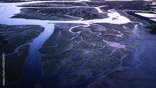 Landscape at sunset. Aerial view from a drone of the landscape of marshes and salt flats of the Ria Formosa Natural Park. Atlantic Ocean. Algarve. Portugal. Europe