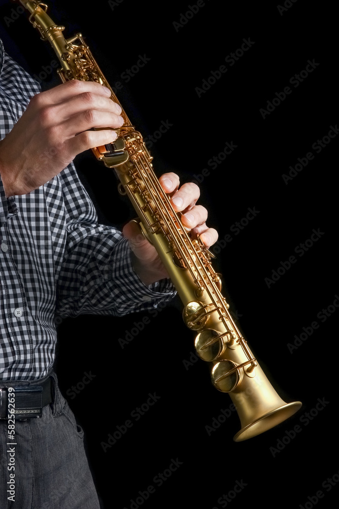 Obraz premium soprano saxophone in hands on a black background