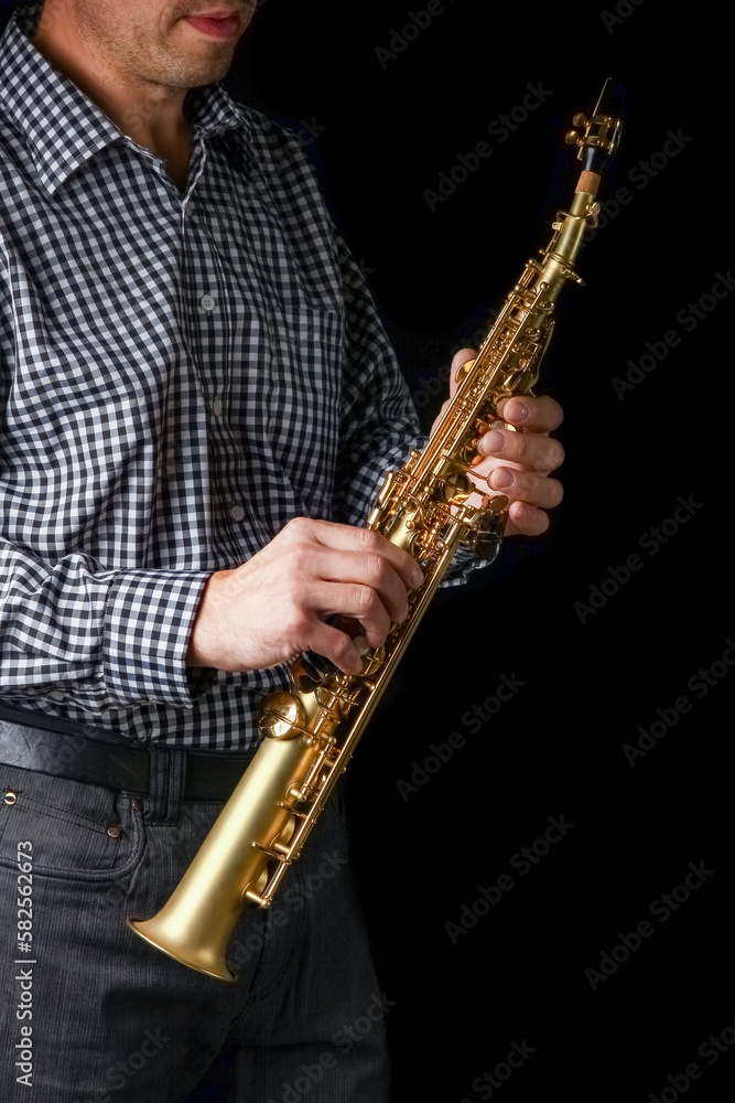 Fototapeta premium soprano saxophone in hands on a black background