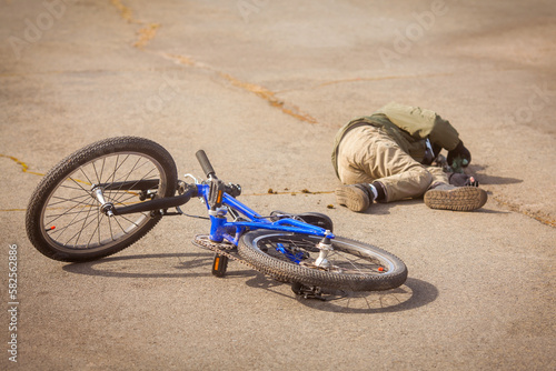 Child fell off the bike. Bicycle accident. Bicycle injury. Road safety and children