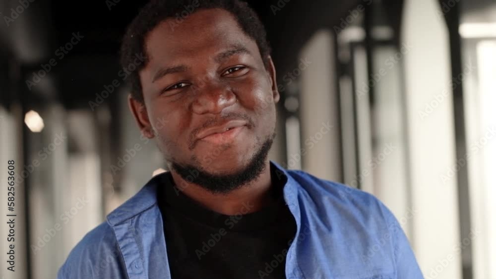 Portrait of happy African American small business owner. Millennial black male team leader smiling, looking at camera, employees working in modern office behind. Head shot. Portrait of happy African American small business owner. Millennial black male team leader smiling, looking at camera, employees working in modern office behind. Head shot.