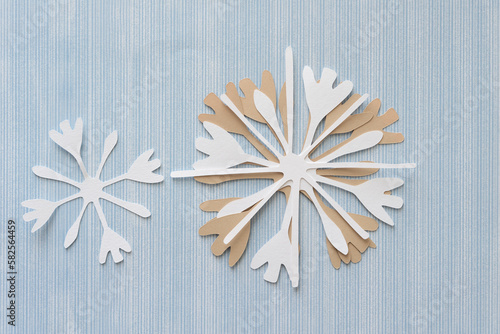 floral snowflake paper cutout on blue scrapbook paper with pattern