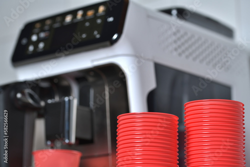 Red plastic cups. Coffee machine in background