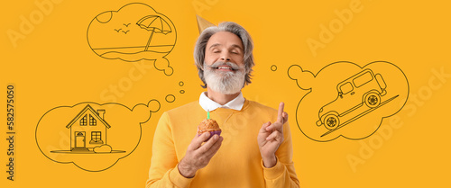 Εκτύπωση καμβά Happy mature man with birthday cake making wish on yellow background