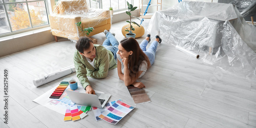 Foto Happy young couple with laptop planning repair in their new house