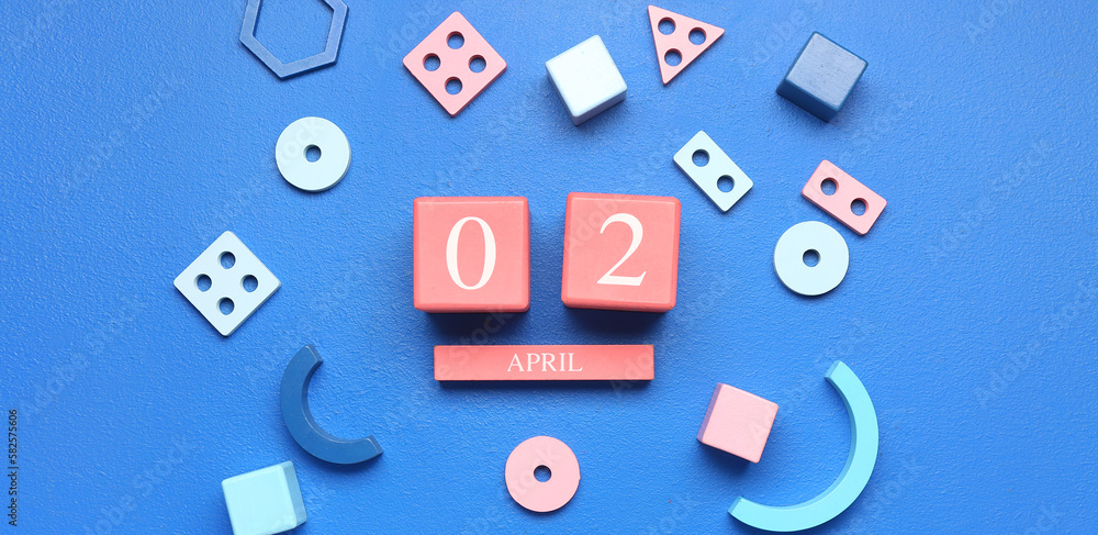 Calendar and toys on blue background. Autism Awareness Day