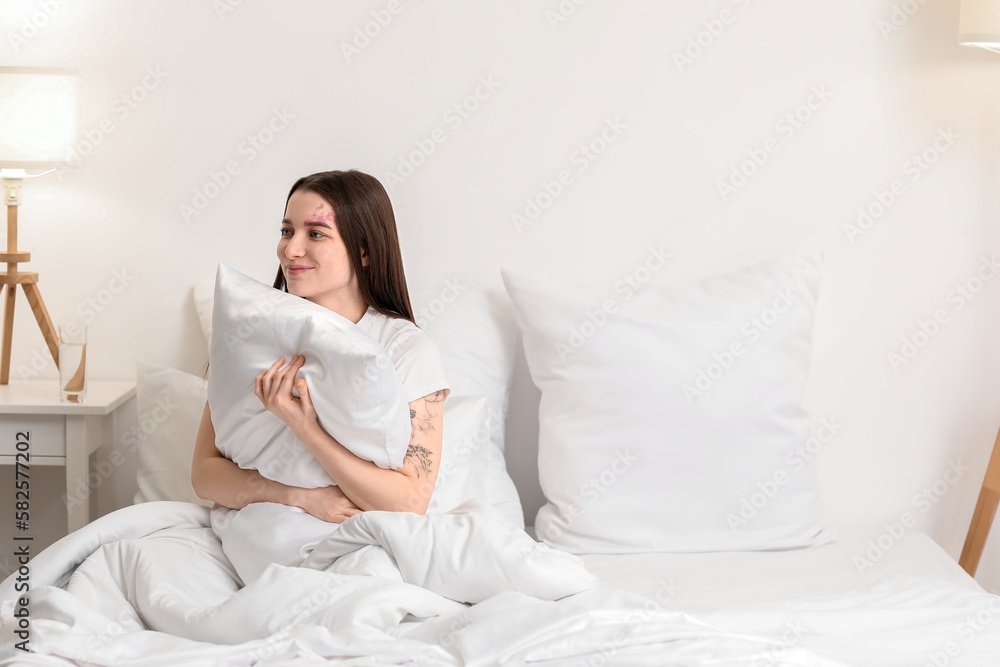 Awaken young woman with pillow sitting on bed in morning Awaken young woman with pillow sitting on bed in morning