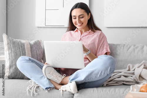 Smiling young woman using l...