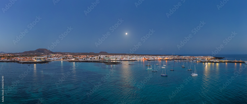 Spectacular low aspect panoramic aerial view of the setting moon early morning over Corralejo Fuerteventura Spain