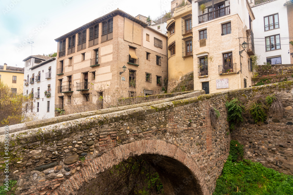Carrera del Darro by the darro river with its historic bridges puente Espinosa and puente del Cadi beneath Alhambra