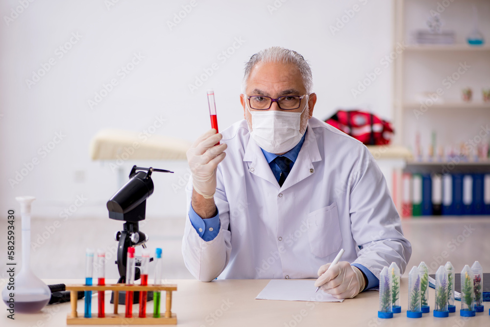 Old male chemist in drugs synthesis concept Old male chemist in drugs synthesis concept