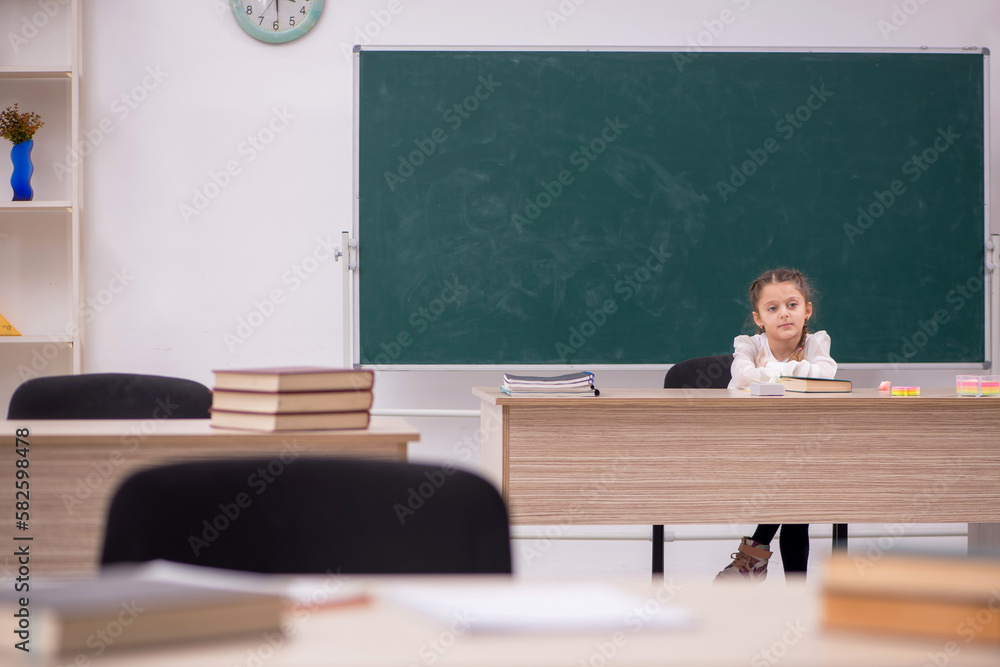 Small girl sitting in the classroom