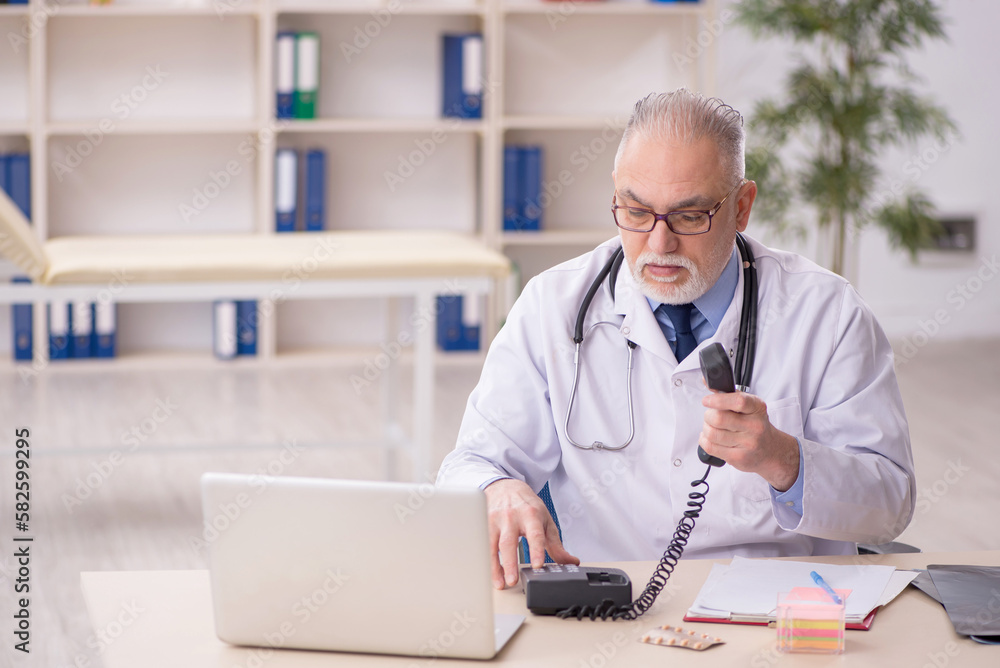 Old male doctor working in the clinic Old male doctor working in the clinic